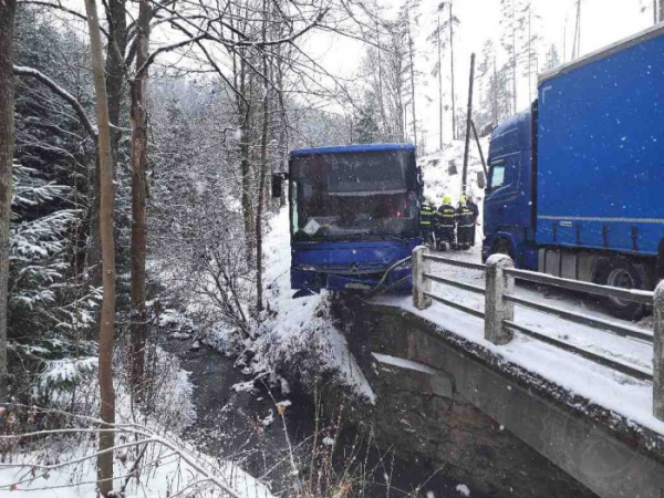 Autobus po střetu s kamionem visel nad potokem, cestovalo v něm osm lidí a řidič